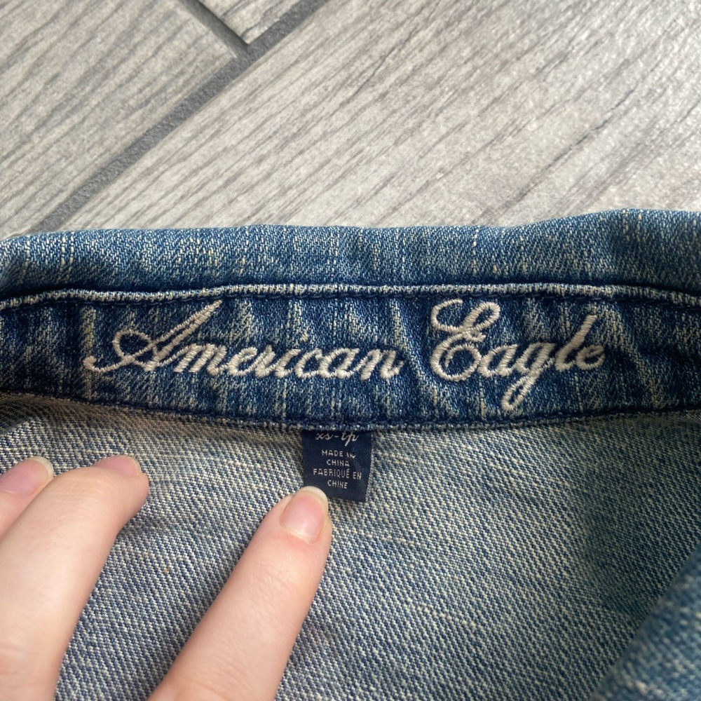 Cropped denim jacket with several patches